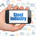 Industry concept: Hand Holding Smartphone with Steel Industry on display Royalty Free Stock Photo