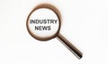 Industry News on a sheet under a magnifying glass