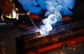 Industry safety working concept. Welder holding a steel welding machine weld piece of metal in a factory at night time. Nice bokeh Royalty Free Stock Photo