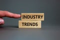 Industry trends symbol. Wooden blocks with words `Industry trends` on beautiful grey background. Male hand. Business and industr