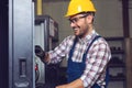 Industry Worker entering data in CNC machine at factory. Royalty Free Stock Photo