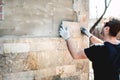 industry worker installing stone tiles on architectural house facade