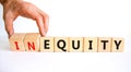 Inequity or equity symbol. Businessman turns wooden cubes and changes the word inequity to equity. Business and inequity or equity