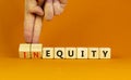 Inequity or equity symbol. Businessman turns wooden cubes and changes the word inequity to equity. Business and inequity or equity