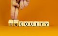 Inequity or equity symbol. Businessman turns wooden cubes and changes the word inequity to equity. Business and inequity or equity