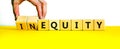 Inequity or equity symbol. Businessman turns wooden cubes and changes the word inequity to equity. Business and inequity or equity