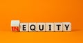 Inequity or equity symbol. Turned wooden cubes and changed the concept word Inequity to Equity. Beautiful orange table orange