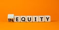 Inequity or equity symbol. Turned wooden cubes and changed the concept word Inequity to Equity. Beautiful orange table orange