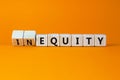 Inequity or equity symbol. Turned wooden cubes and changed the word inequity to equity. Business and inequity or equity concept.