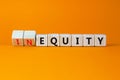 Inequity or equity symbol. Turned wooden cubes and changed the word inequity to equity. Business and inequity or equity concept.