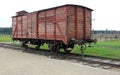 Infamous rail car, barbed wire fence and barracks in the background, of Auschwitz concentration camp Royalty Free Stock Photo