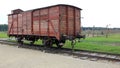 Infamous rail car, barbed wire fence and barracks in the background, of Auschwitz concentration camp Royalty Free Stock Photo