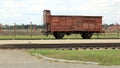 Infamous rail car, barbed wire fence and barracks in the background, of Auschwitz concentration camp Royalty Free Stock Photo