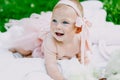 Infancy and age concept . beautiful happy baby in pink dress in the park playing Royalty Free Stock Photo
