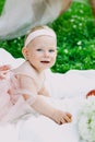 Infancy and age concept . beautiful happy baby in pink dress in the park playing Royalty Free Stock Photo