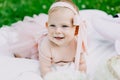 Infancy and age concept . beautiful happy baby in pink dress in the park playing Royalty Free Stock Photo