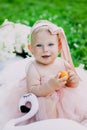 Infancy and age concept . beautiful happy baby in pink dress in the park playing Royalty Free Stock Photo