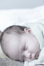 Infancy, childhood, development, medicine and health concept - close-up smiling face of newborn sleeping baby girl lying Royalty Free Stock Photo