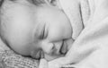 Infancy, childhood, development, medicine and health concept - close-up smiling face of newborn sleeping baby girl lying Royalty Free Stock Photo