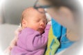 Mom holds her one month old baby girl on the shoulder while she is sleeping.