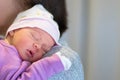 Mom holds her one month old baby girl on the shoulder while she is sleeping.