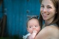 Mom holds her five month old baby girl on her arms.