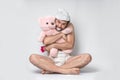 Infant adult man with pacifier in diaper holding pink teddy bear Royalty Free Stock Photo