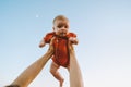 Infant baby being held up in the sky by father hands Royalty Free Stock Photo