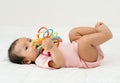 infant baby biting colorful rubber bites toy on bed Royalty Free Stock Photo