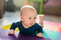 Infant baby boy playing on colorful soft mat. Little child making first crawling steps on floor. Top view from above Royalty Free Stock Photo