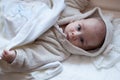 Infant baby girl in bed getting to sleep in bathrobe Royalty Free Stock Photo