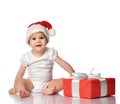 Infant baby girl child in red Santa hat with gift box Royalty Free Stock Photo