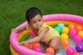 infant baby girl playing water with colorful plastic balls in inflatable pool Royalty Free Stock Photo