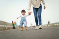 infant baby learn walking first step on pathway with mother holding hand Royalty Free Stock Photo