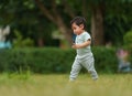 infant baby learning to walking first step on green grass in park Royalty Free Stock Photo