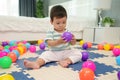 infant baby playing colorful plastic balls on jigsaw mat in bedroom Royalty Free Stock Photo