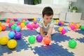 infant baby playing colorful plastic balls on jigsaw mat in bedroom Royalty Free Stock Photo