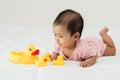 infant baby playing with yellow rubber duck toy on bed Royalty Free Stock Photo