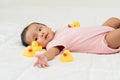infant baby playing with yellow rubber duck toy on bed Royalty Free Stock Photo