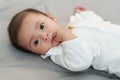 infant baby putting hands in mouth and sucking fingers on bed Royalty Free Stock Photo