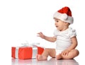 Infant baby in red Santa cap with gift box side view Royalty Free Stock Photo