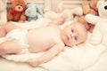 Infant with blue eyes and curious face on light blanket