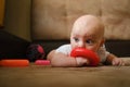 Infant boy playing with developing toy lying on sofa. Cute 4 month old baby boy. Child development concept. Royalty Free Stock Photo
