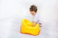 Infant child baby boy toddler play with potty toilet stool pot on a white background Royalty Free Stock Photo