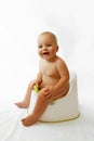 Infant child baby boy toddler sitting on potty toilet stool pot isolated on a white background. Royalty Free Stock Photo