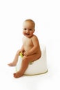 Infant child baby boy toddler sitting on potty toilet stool pot isolated on a white background. Royalty Free Stock Photo