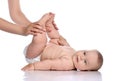 Happy infant baby girl kid in diaper is lying on her back doing exercises, holding feet up with adult coach. Side view Royalty Free Stock Photo