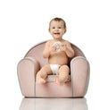 Infant child baby girl kid toddler in diaper sit in little armchair chair eat donut Royalty Free Stock Photo