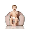 Infant child baby girl kid toddler in diaper sit in little armchair chair Royalty Free Stock Photo