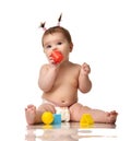 Infant child baby toddler sitting in diaper with yellow blue and red educational toys playing isolated Royalty Free Stock Photo